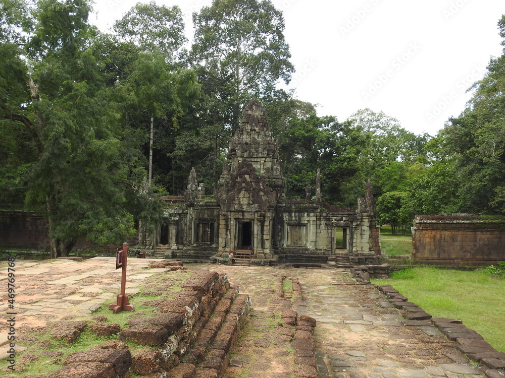 Angkor Wat temple in the Cambodian jungle. giant tree roots growing out of the old architecture, wonderful bas-reliefs