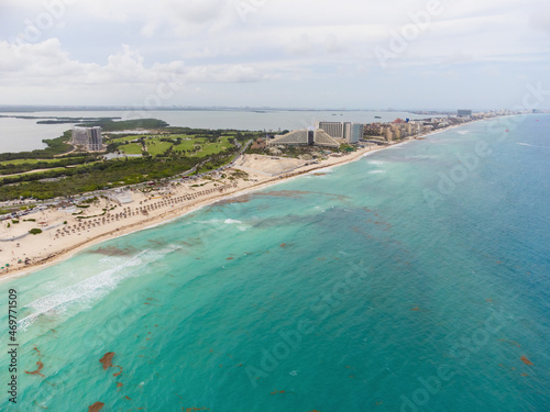 Aerial photograph. Sandy white beach and sea blue water. Resort and tourist place. Pollution by seaweed and water debris. Environmental and social problems, global warming.