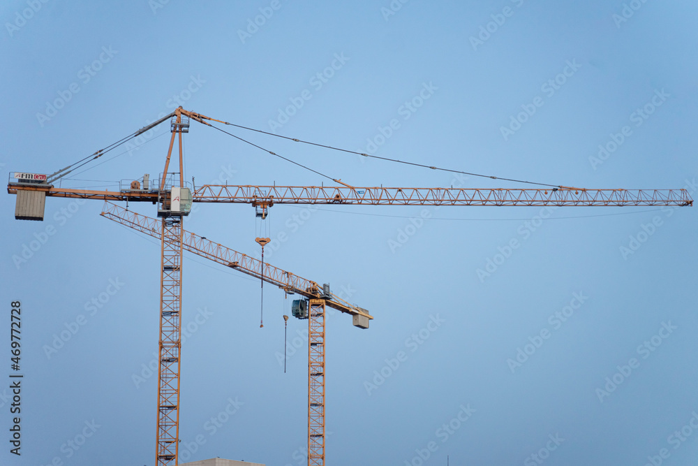 construction crane on a background of clear blue sky stands motionless, construction equipment, urban town building construction crane on a background of clear blue sky stands motionless, construction equipment, urban town building