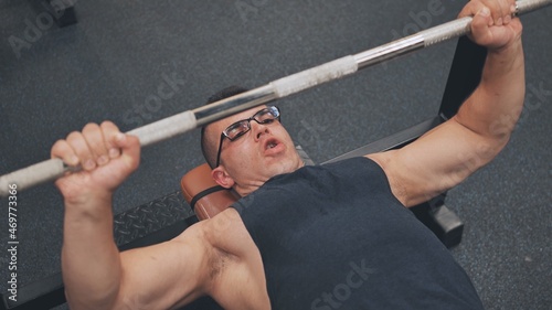 An Arab man pumps his chest in the gym.