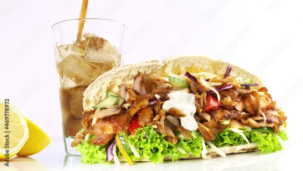 Cola in ein Glas einschenken mit Fast Food auf weißem Hintergrund