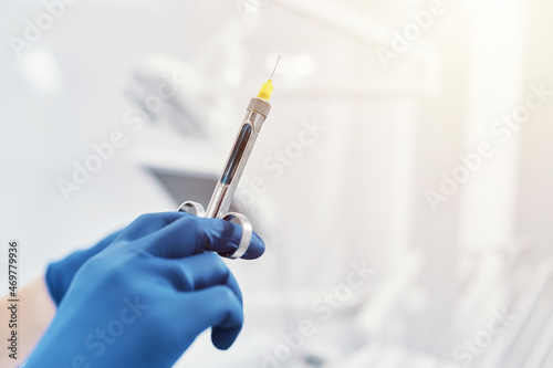 
a dentist holds a dental syringe in a dental clinic