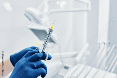 
a dentist holds a dental syringe in a dental clinic