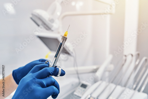 
a dentist holds a dental syringe in a dental clinic