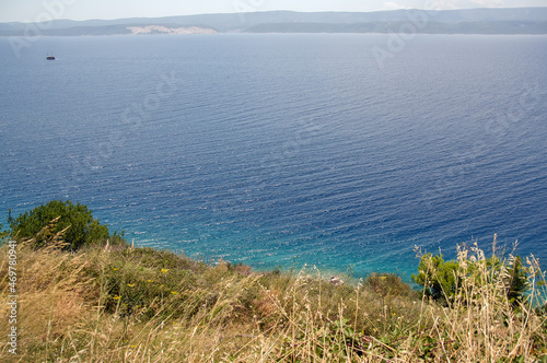 Samotna łódka na środku błękitnej wody i górami na horyzoncie