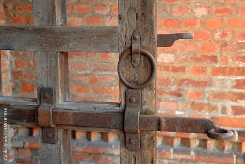 Antique gate with latch on red brick wall