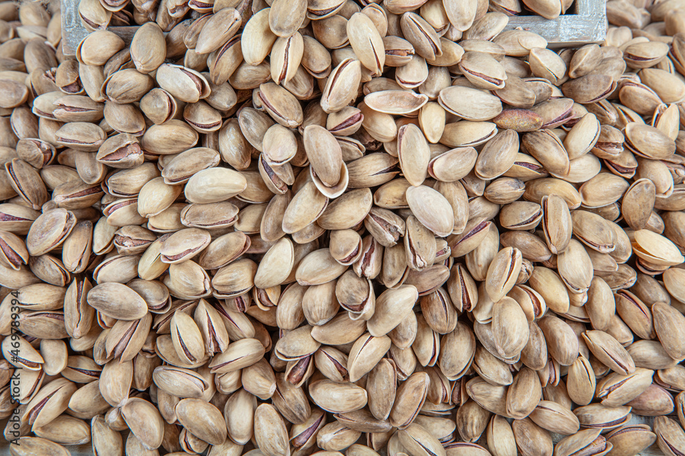 Pistachio nuts. Roasted and salted peanuts in the shell (texture, background). Tasty pistachios as background,as pistachios texture. flat lay