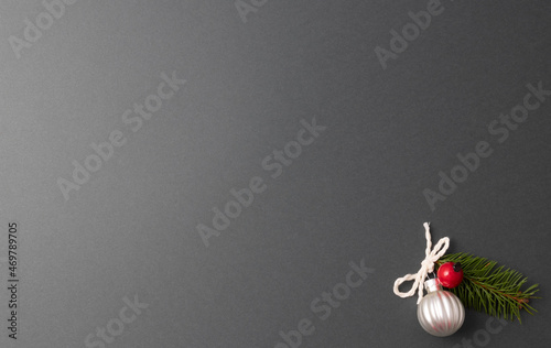 The minimal Christmas Concept is a silver ball and a red berry on a gray background. A greeting card. free space for signature. Top view.