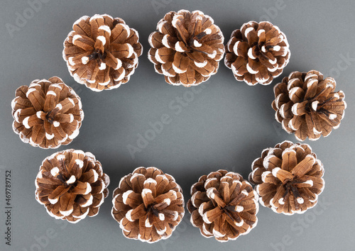 Decorative pine cones on a dark gray background, the basis for a greeting card for Christmas and new Year 2022. Top view.