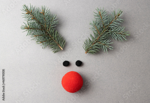 A decorative deer muzzle with horns made of coniferous branches, a nose made of red foam rubber and eyes made of black cotton wool. The concept of celebrating Christmas and New Year 2022