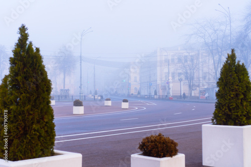 Foggy autumn morning in the City of Gomel. Deep fog on the city street in cold dark autumn morning photo