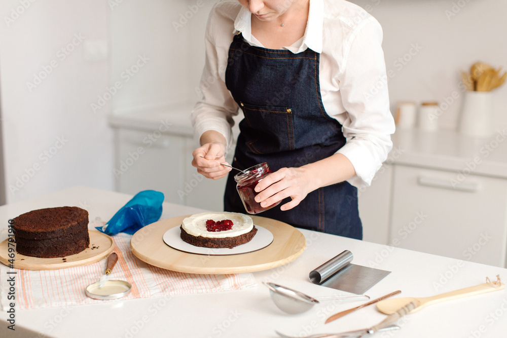 Woman making chocolate cake in kitchen, close-up. Lays berries. Female hands close up. Cake making process, Selective focus. High quality photo Woman making chocolate cake in kitchen, close-up. Lays berries. Female hands close up. Cake making process, Selective focus. High quality photo