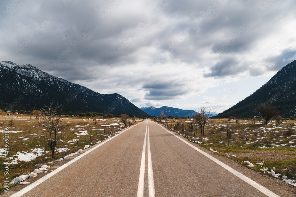 Naklejka premium Empty asphalt road in the middle of mountainous area. Highlands of Greece, winter time. Freedom, travel concept.
