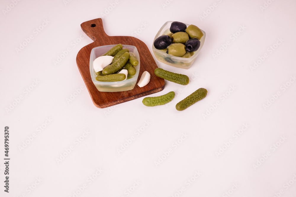 Pickles cucumbers with garlic on a white plate. Russian menu. Pickles cucumbers with garlic on a white plate. Russian menu.