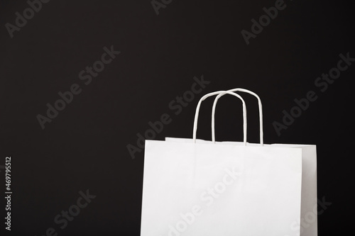 Blank white paper bag isolated on black background. Black friday, sale, discount, recycling, shopping and ecology concept.