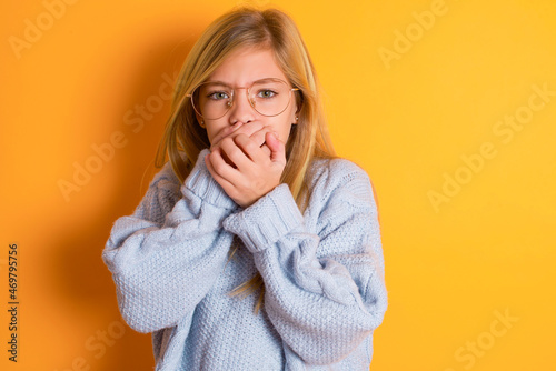 Φωτογραφία caucasian kid girl wearing blue knitted sweater over yellow background  holding