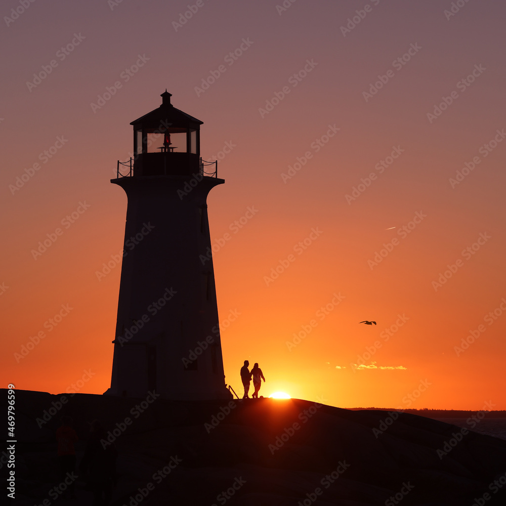 A couple holding their hands in the silhouette background of a lighthouse on a beautiful sunset full of red and orange sky. Valentine
Peggy's Cove Lighthouse, Halifax, Nova Scotia, Canada