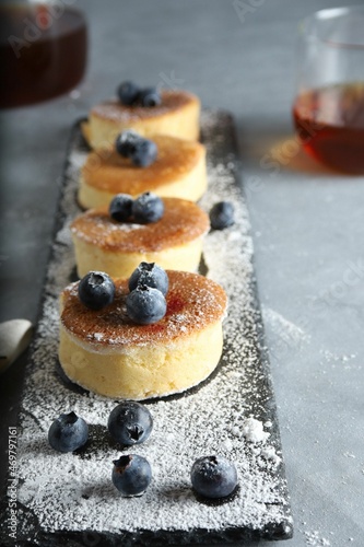 Trendy asian food, Fluffy Japanese Souffle Pancakes, Hotcakes with sugar powder , berries and tea, lightr background. photo