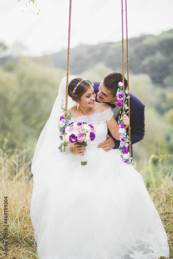 Perfect couple bride, groom posing and kissing in their wedding day Perfect couple bride, groom posing and kissing in their wedding day