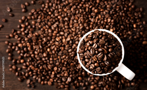 coffee beans in a white mug on a dark wooden background