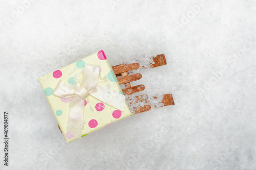 Gift box on a wooden sleigh in the snow. Top view