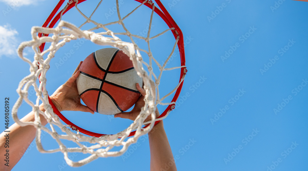 basketball ball flying through basket in players hands, copy space, targeting basketball ball flying through basket in players hands, copy space, targeting