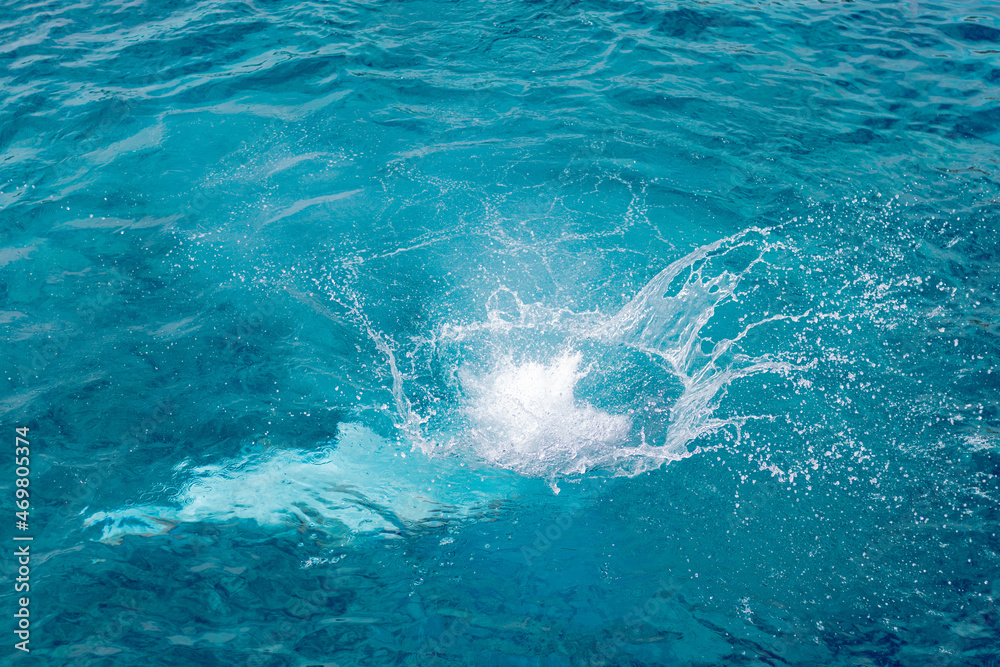 Obraz premium Splashes of blue, sea water with foam bubbles. A splash of nature on a summer day. blue sea background with splashing water. sea vacation concept.