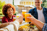 Group of multiethnic happy friends living healthy lifestyle and relaxing while drinking beer at outdoor pub restaurant - Young people enjoying drinks during happy hour at bar