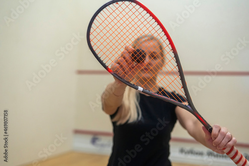 blonde girl holding a racket for squash games photo