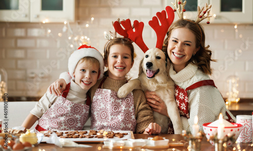 Happy family mother, two kids with dog golden retriever in kitchen, preparing Christmas cookies photo