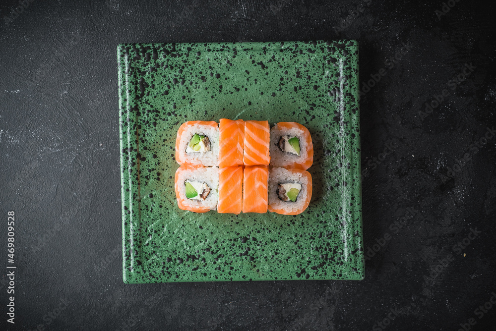 sushi with salmon on a black plate