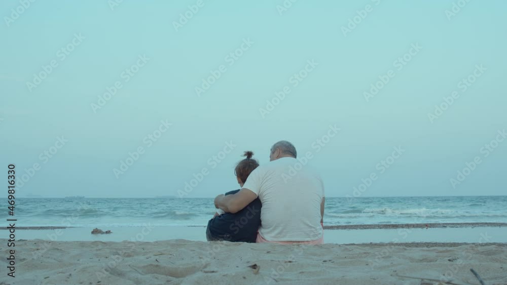 Grandfather and grandson are sitting on the shore Grandfather and grandson are sitting on the shore