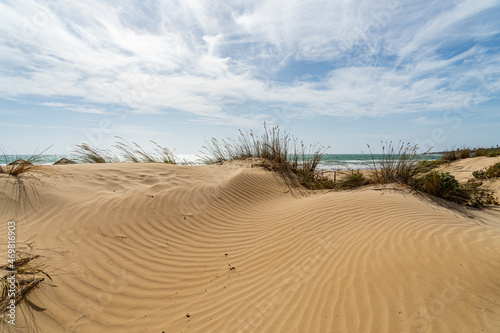 Blick über eine Sanddüne auf Wolken und Meer