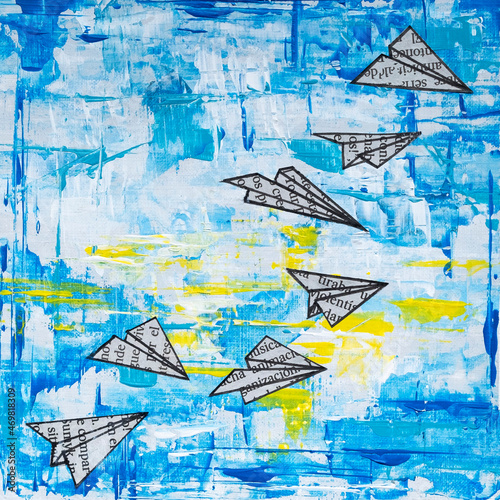 Collage illustration of paper airplanes made with newspaper leaflets flying over a blue sky with white clouds and yellow traces