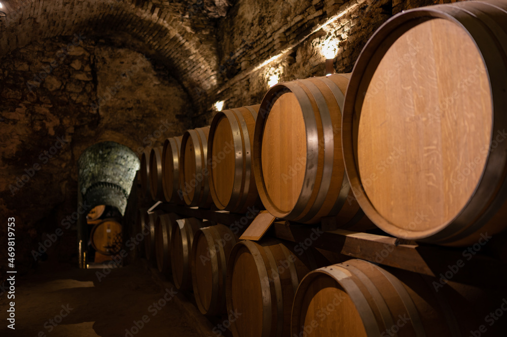 Medieval underground wine cellars with old red wine barrels for aging of vino nobile di Montepulciano in old town Montepulciano in Tuscany, Italy
