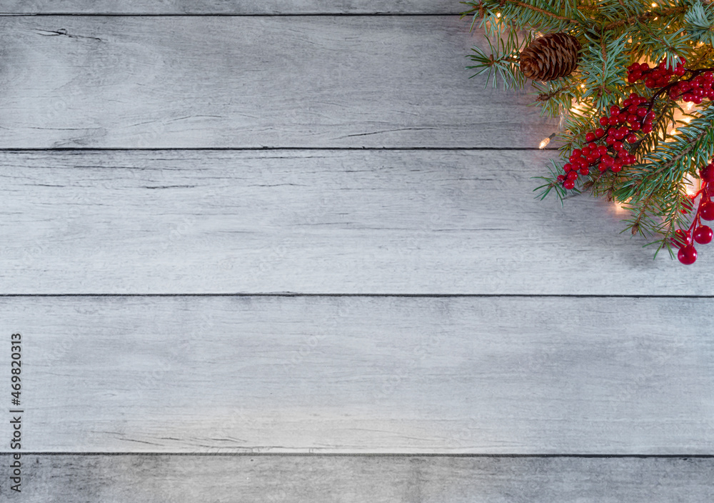 Creative winter holidays layout. Made of Christmas tree lights, pine, red berries and cones on white wooden boards. Minimal New Year and Christmas concept background. With copy space. Creative winter holidays layout. Made of Christmas tree lights, pine, red berries and cones on white wooden boards. Minimal New Year and Christmas concept background. With copy space.