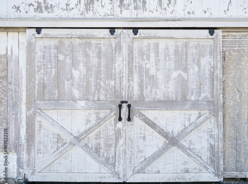 Sliding rustic barn or stable doors. White barn wood with rustic finish.