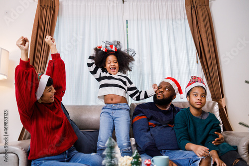 African American girl dancing and enjoying with her family. African American family in Christmas theme