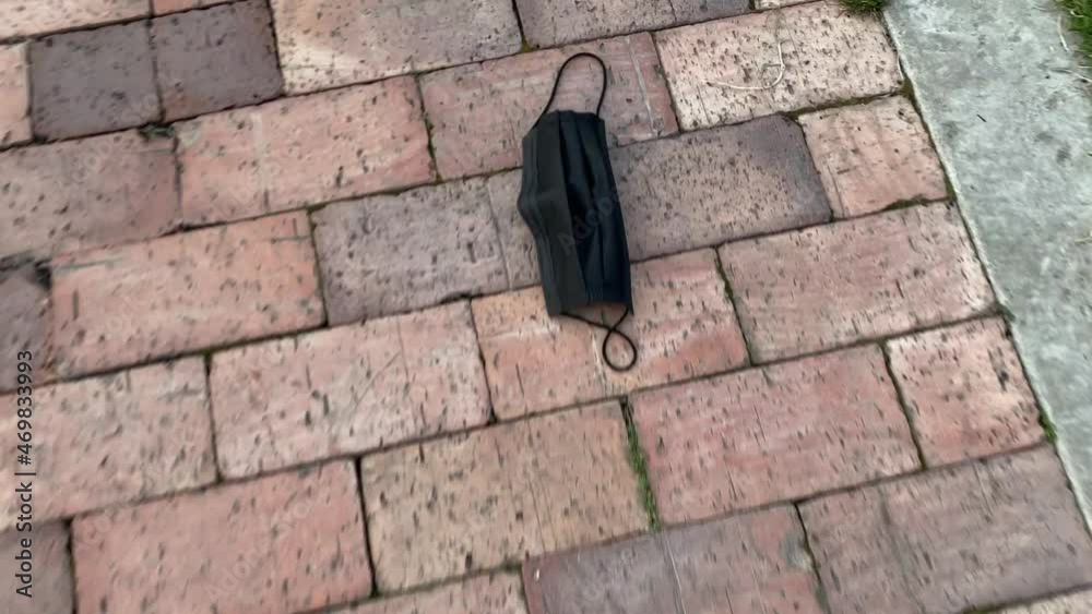 Tapabocas negro en el piso de un parque 