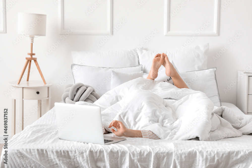 Morning of young woman with laptop lying in bed Morning of young woman with laptop lying in bed
