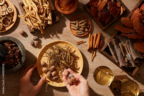 Traditional chinese medicine with herb and spices in brown wooden background mortar and pestile , for medicine advertising , photography traditional medicine content photo