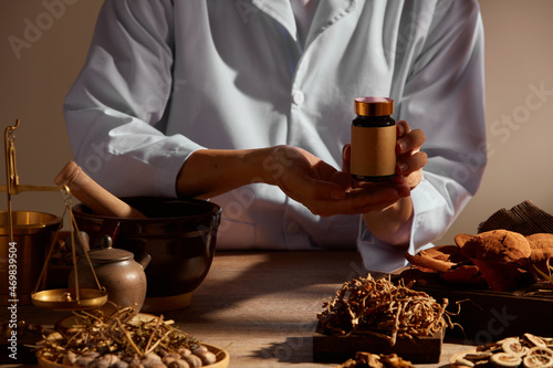 Fotografie Traditional chinese medicine with herb and spices in brown wooden background mor