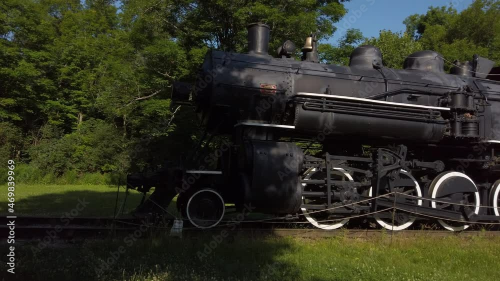 Wide panning shot from train tracks over to an old steam locomotive Wide panning shot from train tracks over to an old steam locomotive