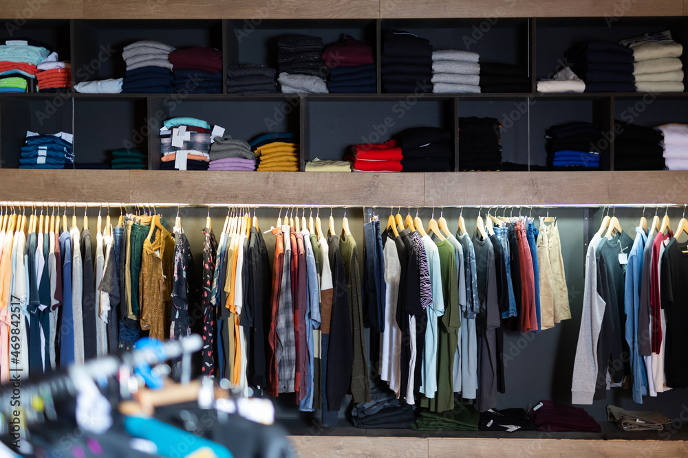 Male clothes on hangers and shelves in apparel market