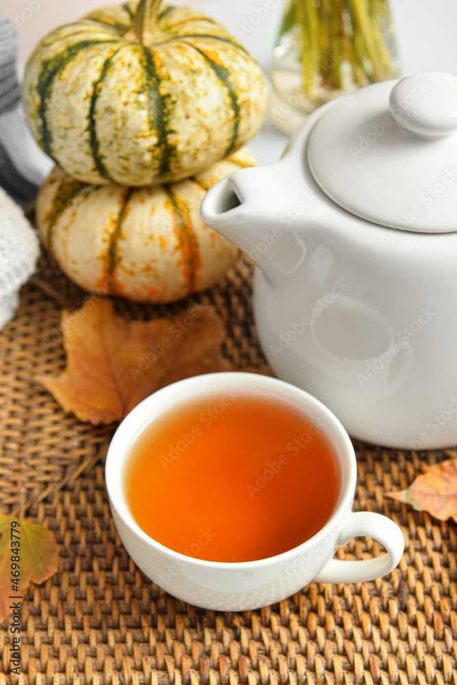 Tea pot, cup of hot beverage and autumn leaves on table Tea pot, cup of hot beverage and autumn leaves on table