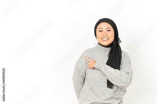 Pointing aside of Beautiful Asian Woman Wearing Hijab Isolated On White Background © Sino Images Studio