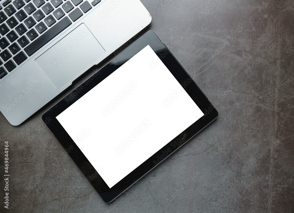 Business desk office with laptop, and digital tablet with blank screen on black wood table. Flat lay top view copy space. Business desk office with laptop, and digital tablet with blank screen on black wood table. Flat lay top view copy space.