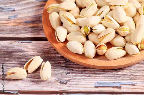 The pistachios are on the wooden board