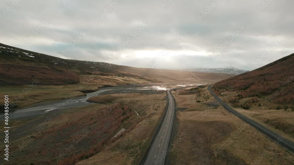 Aerial flyover above Iceland highway illuminated by sun beams in beautiful river valley. Aerial flyover above Iceland highway illuminated by sun beams in beautiful river valley.