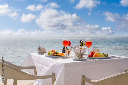 Luxury breakfast table with food for two with beautiful tropical sea view background. Morning couple time summer holiday and romantic vacation concept, luxury travel and lifestyle, destination dining